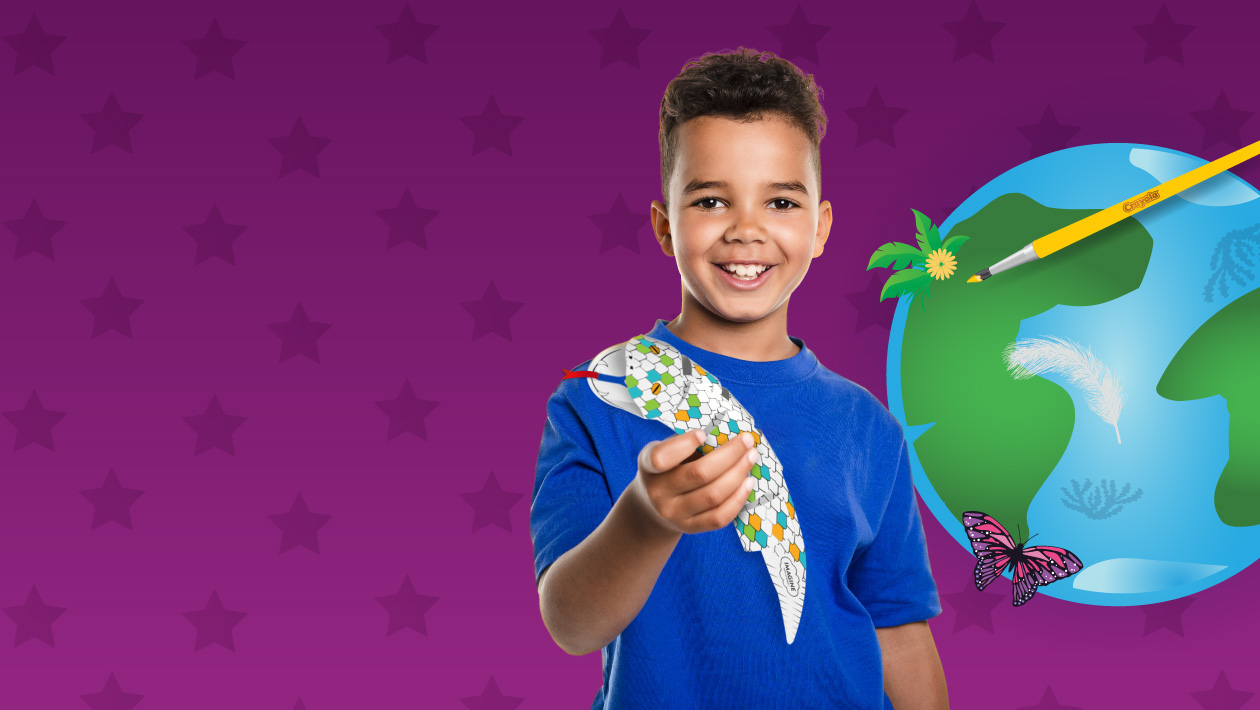 Boy holding a Crayola Imagine Arts Academy take home snake that he competed. An illustration of earth, a butterfly and a pain
